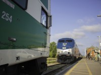 <b> The Big Game is on! </b> Amtrak 189, the "Big Game Unit" squares off with GO cabcar 254 in this battle for territory at Niagara Falls station. While GO 787/788 has had this problem with Amtrak all summer, the faces have gotten closer because GO is now running 12 car trips to Niagara Falls because of the CNE, and the entire GO train wouldn't even fit on the platform. 10 minutes of spotting to know what doors couldn't be opened discovered that only 10 cars were on the platform. With each train not even 20 feet apart, the shadows of the GO cabcar bell and horn are shown on the nose of the Amtrak unit. In the end, the "Big Game Unit" won the battle as it had arrived well before the GO did, and was nearly done customs. The GO backed out out, and proceeded onto the far track, before coming back into the station. Considering this is Rule 105, or "Dark Territory", the RTC was not involved, and efficiently handled only by the two train crews. 