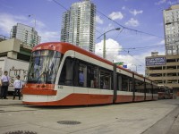 On the first day of the new low-floor Flexity streetcars in service on the TTC system, 4400 rests its bendy 5 sections at Queens Quay/Spadina Loop. I tell ya, the turnout for the only two new Flexity's in service was incredible, and passengers were so happy they gave a round of applause at Spadina Station. I almost made the first one, 4403, however I wanted to enjoy my first ride, not be a sardine. It was worth the wait, and I got a seat on 4400 to Queens Quay. Here it dwarfs a highly underappreciated CLRV behind it. One of these days, the Flexity's will just be another TTC vehicle to passengers, much like the CLRV. However, one thing I'm sure that will be appreciated is with the amount of these high capacity sets ordered, they should greatly increase overall capacity on the streetcar network. The only issue that's bothered me is the destination signs appeared to be displaying improperly on both sets that were out on Spadina, and appears to be an issue on the other two that weren't in service today. Other than that, I'll be glad to see these make their way into the system. The TTC sure picked an eventful day for the new streetcars to roll out. Just minutes after 4400 left northbound, the "ship horn" from the Rogers Centre went off with fans letting out a good roar, easily heard from Queens Quay. Meanwhile, the air show was occurring, and of course the chaotic CNE. 