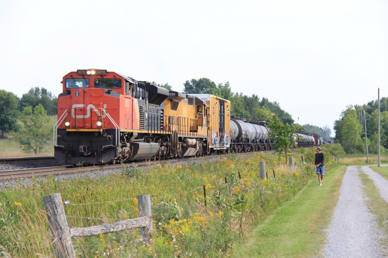 A friendly conductor on 413 and a railfan exchange greetings at the North end of Brechin. 413 had just met 106 and was about to depart with a diverging to clear.