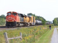 A friendly conductor on 413 and a railfan exchange greetings at the North end of Brechin. 413 had just met 106 and was about to depart with a diverging to clear. 