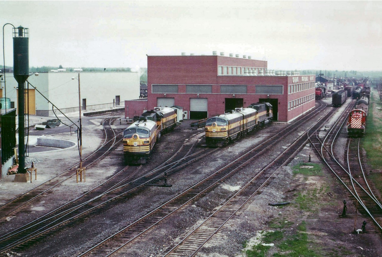 One of those hot humid and very hazy days in May that North Bay can experience from time to time, but not that often in the Spring resulted in this interesting view of the ONR shop looking rather flat. Four F units in the image, and since I did not take down the numbers, only 1520 and I think 1508 are visible. Its a busy yard back there, a CN unit and off to the right a CP ALCO switcher can be seen. Photo taken from off the Main St overpass, and this view, other than the power, has changed little from 1975. I did a lot of wandering in the yard this day, but I understand now the area is off limits to us foamers.