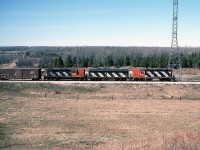 CN GP9 4252, F7Bu 9195 and RS18 3704 are in charge of a freight on the Douglas Point Spur near   Port Elgin. The Douglas Point Spur ran off the Southampton Sub, southwest from Port Elgin to the Bruce Nuclear Generating Plant at Douglas Point, just to the north of Kincardine. This line and much of the Owen Sound Subdivision would be abandoned in 1989, and the spur is now part of the Bruce County Rail Trail. <br><br> <i>Note: Geotagged location may not be exact.</i>