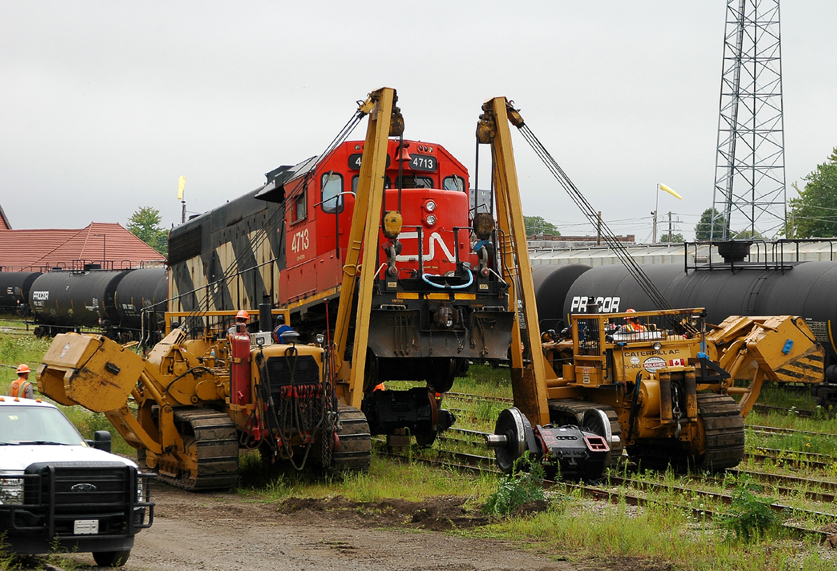 After being set off by 435 the previous day, we see CN 4713 receiving a new traction motor with some help from a pair of Hulcher's Caterpillar 583H side boom's