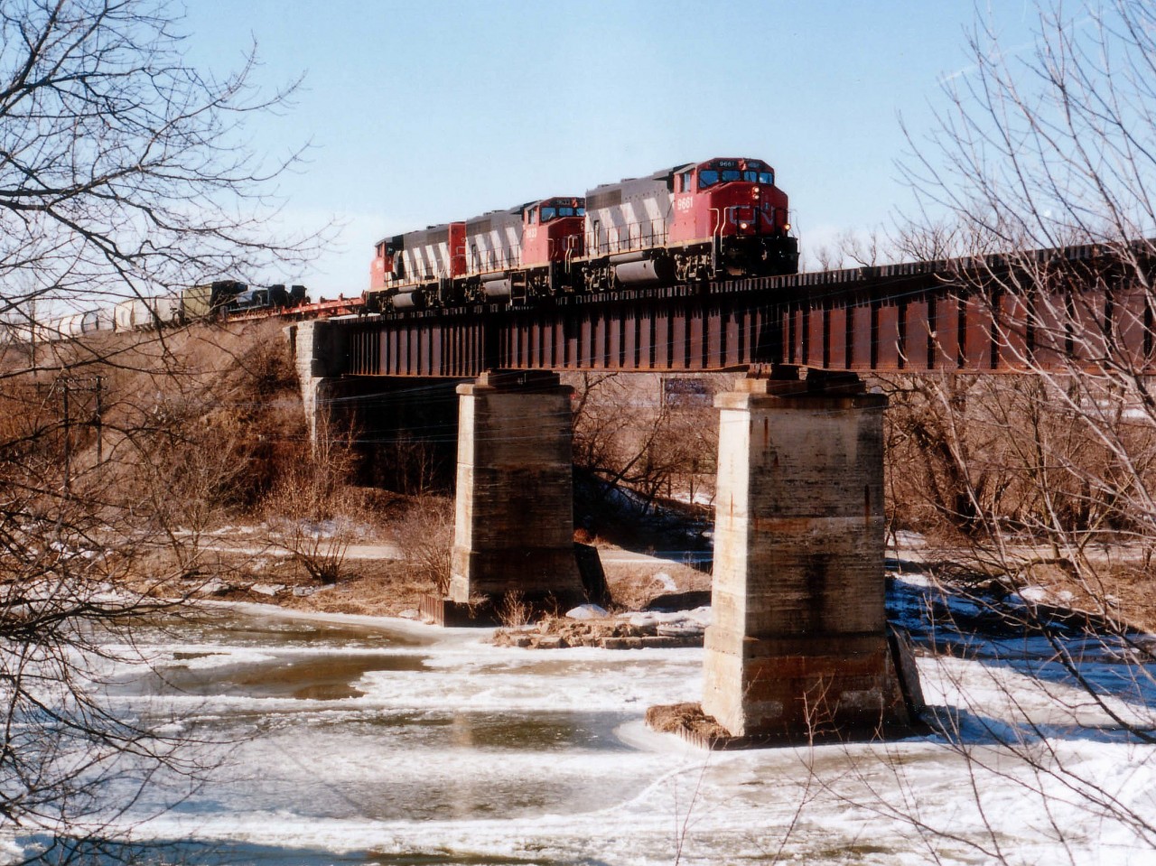 The GEXR expanded from its original startup in 1992 for the first time on November 16, 1998 with the acquisition of the CN Guelph Subdivision. The line brought in 6 units from other RaiLink roads for the takeover. The usual power problems resulted in GEXR leasing for brief periods units from the CN as well, thirty days at a time, I'm told. February 1999 was the only month the three in this image were together. And this was one of the rare times I was able to successfully snag a shot of a train rolling over the Grand River bridge. A lot of chopping, sawing and weeding preceded this event. Nowadays this area is all housing.......CN 9661, 9633 and 9643 power eastward toward Mac Yd from Stratford; I was a bit peeved there was no genuine GEXR loco in the consist, but one takes what one is offered. It looks to be a regular pre-GEXR train of the CN, but it isn't. It IS part of history though.