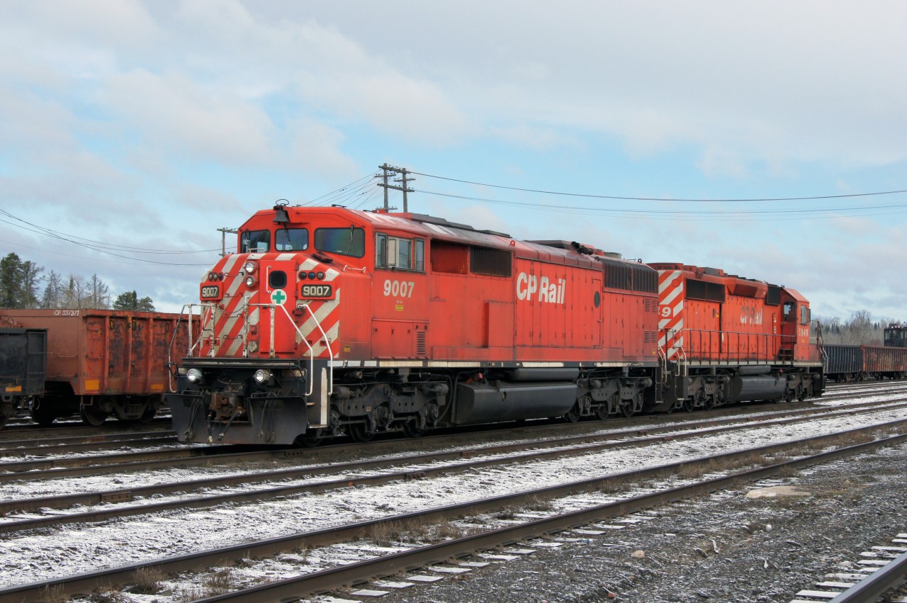 Surrounded by maintenance of way equipment and a dusting of snow, these units wait for duty on a brisk May morning in CP's yard at White River.