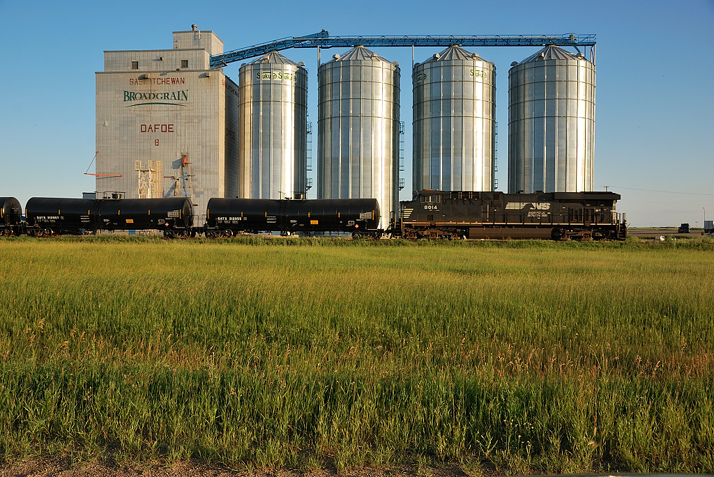 NS 8014 shoves on the rear of CP 616 as it passes the Elevator in Dafoe, SK.
