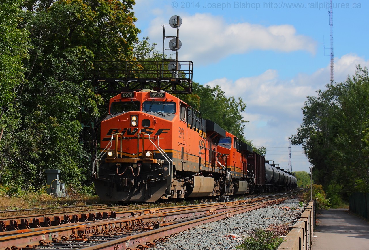 BNSF 5976 and BNSF 6421 lead CN U711 under signal 227N in Brantford with 100 empty tank cars heading back to be refilled.