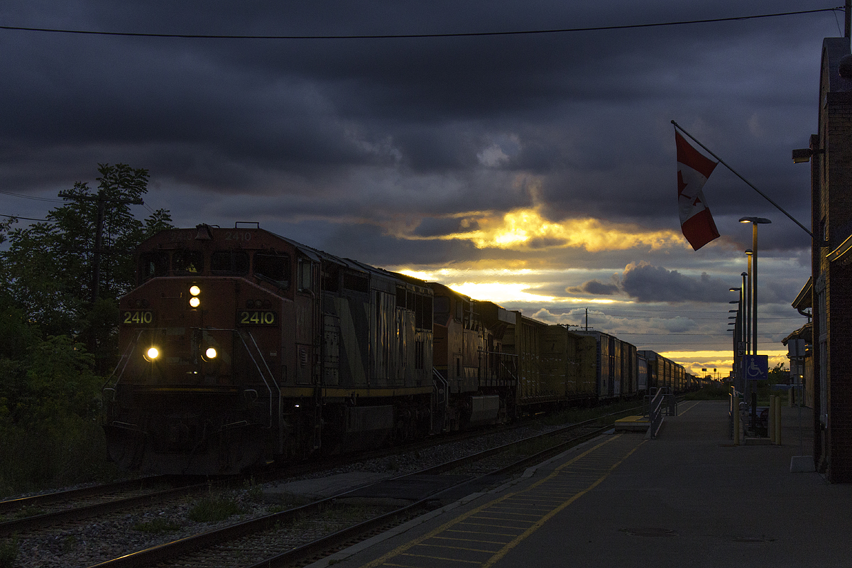 While I thought the possibility of catching CN 330 in a wicked sunset was over with the shortening days, this easily has to be the most interesting lighting I've ever received with a picture of a train in it. With heavy cloud cover, small slivers of sunlight reach through. While it may appear the sun is peering through the clouds, the sun is actually far off to the right of this picture, just a few minutes from dipping below the horizon. Here, CN 330 passes St. Catharines with a zebra GE cowl leader. Hearing the distinctive whine of an ES44AC, I was expecting it to be a CN, however the lashups from Sarnia never fail to surprise. After crawling all the way from Grimsby, the Welland Canal bridge was finally put down, and 330 throttled up coming out of the Jordan dip. Even though this train is less than 50 cars long, CN 2410 and BNSF 5837 are really putting in effort to get up to speed, evident by the heat distortion which is blurring the sunlight above the ES44AC.