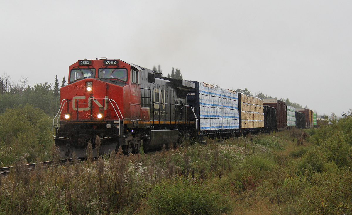 HEAHAW! The fool in the rain... I wasn't going to pass up a good looking 572 (well of course I get stuck with the single Dash-9 of the three ACR consists)... With the back of the van opened for shelter, CN 572 makes the trek South with a track warrent from Wyborn to Oba and 22 cars trailing with Tembec, Landrienne, Lecours, Eacom lumber ; Columbia Forest Products and Val Dor plywood ; Zinc from Xstrata, Dumas for Teck ; and some scrap metal for the Soo.