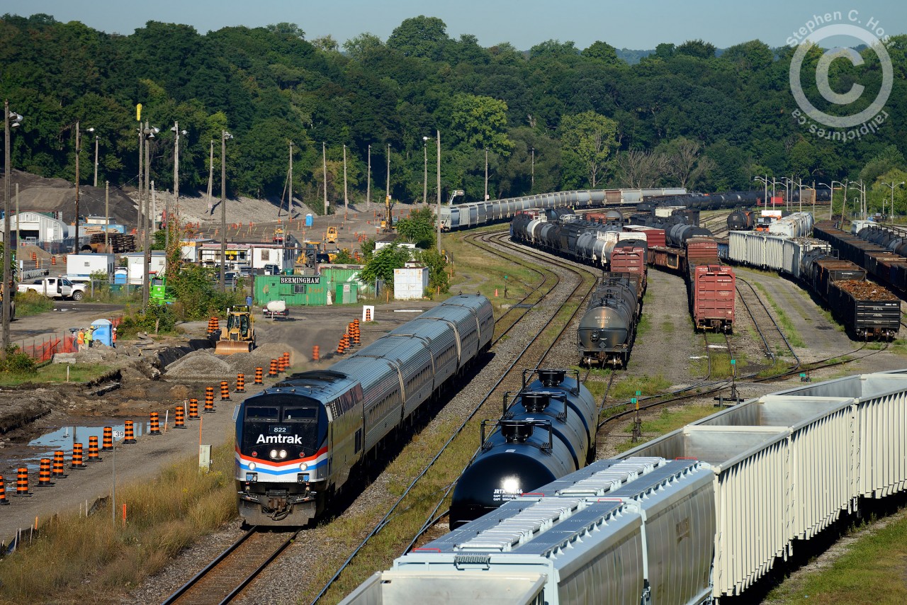 It's morning and Amtrak 97 has 822 in the lead in this busy scene - GO construction hard at work grading the right of way for two new tracks for James St. North.