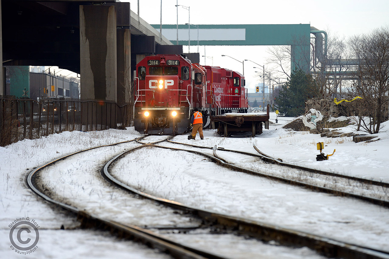 Hamilton yard job TH12 is arriving at National Steel Car on the joint section SOR/CPR Lysaught Lead to lift a cut of cars. A NSC flatcar, used for in-plant moves sits on the former scale track at right, with the scale removed around the 2001 time period. At left is the elevated Gardiner-esque Burlington St and associated Dofasco 'bridges'. If one is lucky, you may see Dofasco industrial engines in this spot (crossing diamond behind engines) but you'd have to be very lucky - moves have gone from once a month to maybe a couple times a year.