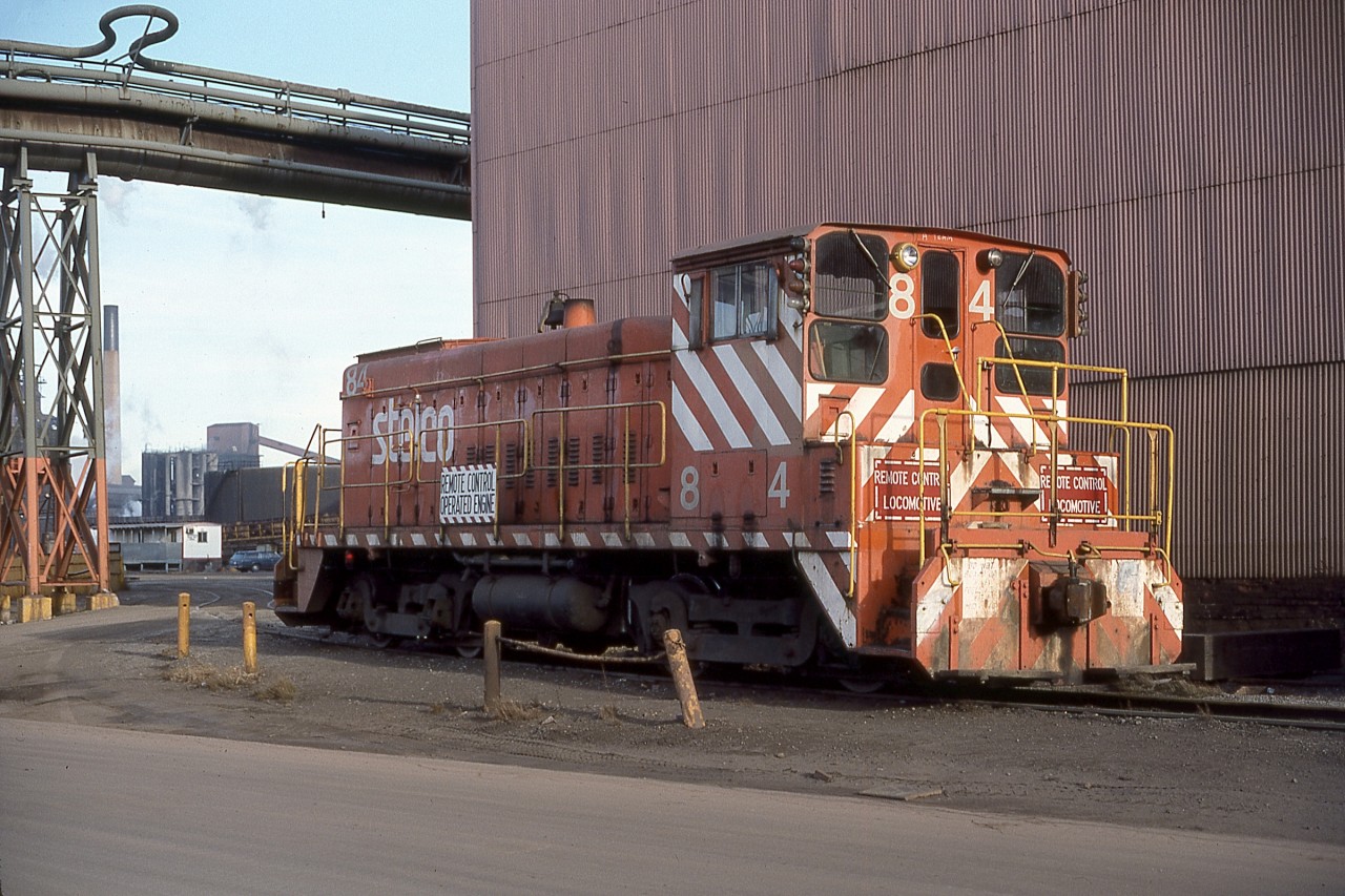 A late December (Boxing Day’s Boxing Day!) morning finds Stelco SW900 No. 84 (GMD November 1959) quietly awaiting her next assignment. Note the alternate AAR Type B trucks styles; converted under the front end, roller bearing under the rear of the unit. Note also that her safety orange dress appears to match the lower section of the pipe bridge support tower to the left. For an updated view see Steve Host’s image; http://www.railpictures.ca/?attachment_id=16419