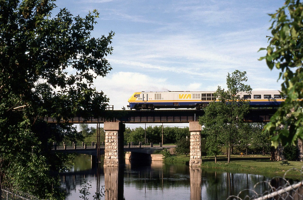 VIA train 66 behind Bombardier LRC-2 locomotive 6918 crosses the viaduct on CN's Belleville Sub over the still waters of the Napanee River.