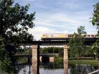 VIA train 66 behind Bombardier LRC-2 locomotive 6918 crosses the viaduct on CN's Belleville Sub over the still waters of the Napanee River.