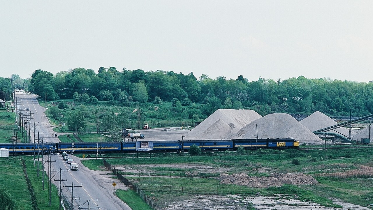 A pair of  MLW 's,  FPA-4 and FPB-4,  have the Montreal morning departure Lakeshore at speed through the McCowan Road crossing on the approach to CN Scarboro Junction. At this date train #53  offered Via 1 and checked baggage services.


For those who maybe familiar with the westend of the Kingston Subdivision – near the Eglinton Go station – this area is almost unrecognizable today, changes include


- the aggregate business and associated rail access / sidings long gone


- grade separation – McCowan now passes under the Kingston Subdivision


- a big box hardware retailer now occupies the south east (left) corner Eglinton – McCowan


- housing development on the south side of the Kingston Subdivision – east (left)  side of McCowan


- several apartment buildings at the south west (right) corner Eglinton – McCowan:  nursing home / seniors residence  and two separate condominium towers


The view from my condo, spring 1984 Kodachrome by S. Danko


sdfourty.