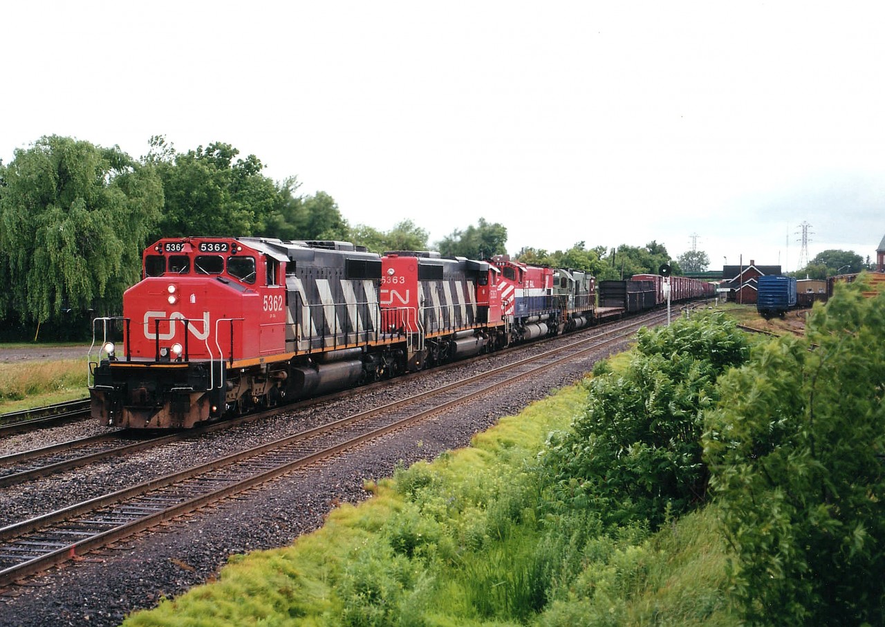Heading to the USA and Conrail's Frontier Yard in Buffalo, CN 5362 and 5363 have in tow two newly retired M630(W) locos late of BC Rail; 730 and 701, sold to General Electric. In this time frame quite a number of these '630' locomotives went to GE, and they gathered en-mass at Frontier. Of the CN SD40-2(W, numerically the last two of a large block on the roster (5241-5363) the 5362 was still active as of early 2014 whilst the other was retired in 2010. In the background on the right one can see the old Merritton city yard, as well as the station, which burned down a few years later.