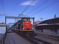 A pair of centre-cab electrics led by CN 6726 slow to a stop at Val-Royal during the evening rush hour with  a train of VIA coaches retired from intercity service. 