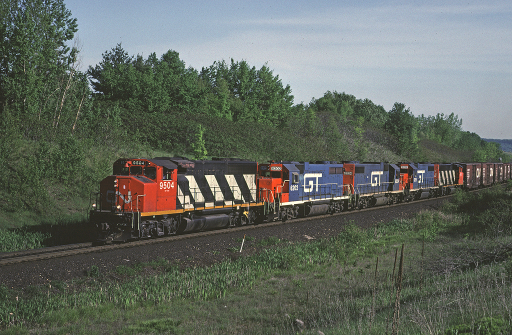 A Grand Trunk Western sandwich! CN 9504 leads an eastbound between Milbase and Speyside on the Halton Sub, assisted by 3 GTW locos and a 2nd GP40-2W.