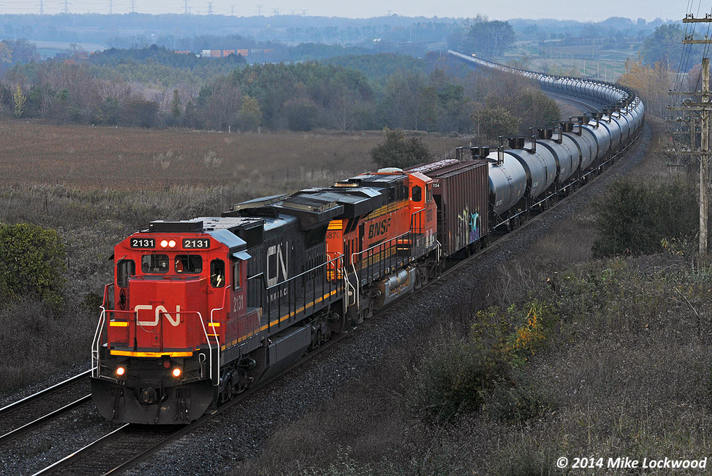 A slight kiss of sun brightens the power on westbound crude empties at Newtonville. CN 2131 and BNSF 5780. 1722hrs.