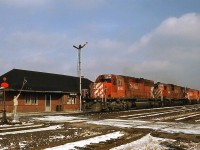 CP 5995 on the westbound "Pick Up" rolls into Guelph Junction, with the station attendant at the ready with orders to be hooped up to the westbound. Trailing SD40-2 5995 are C630M 4504, SW1200RS 8153(?), and four units that would be set off here at the junction (most appear to be RS18 roadswitchers).