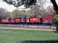  RS18 sandwich: white extra flags waving, little CP SW1200RS units 8130 and 8141 bracket RS18 roadswitcher 8797 on a westbound freight by Lambton Park, on the Galt Sub between the Scarlett Road and Humber mileboards.