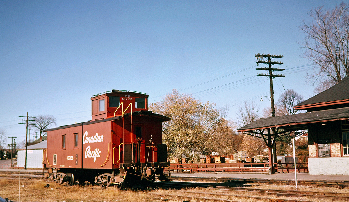 CP 437136 waits out the weekend in front of the Peterborough station. Ex CPR 4-6-0 1057 was to arrive later on an excursion but was short turned at Dranoel due to a running gear issue. The station lost it's canopy a few years later. The schedule board for Dayliner service probably went at the same time. The caboose was preserved in White River. Some details in this photo, 437136 is sporting a backup whistle. The silver post in front of the canopy was the "circuit end" sign for the crossing of George Street. Behind the caboose is Rehill Building Supply which still had a siding and coal pile. Photo probably taken by my Mother with editing assistance by the RP folk.