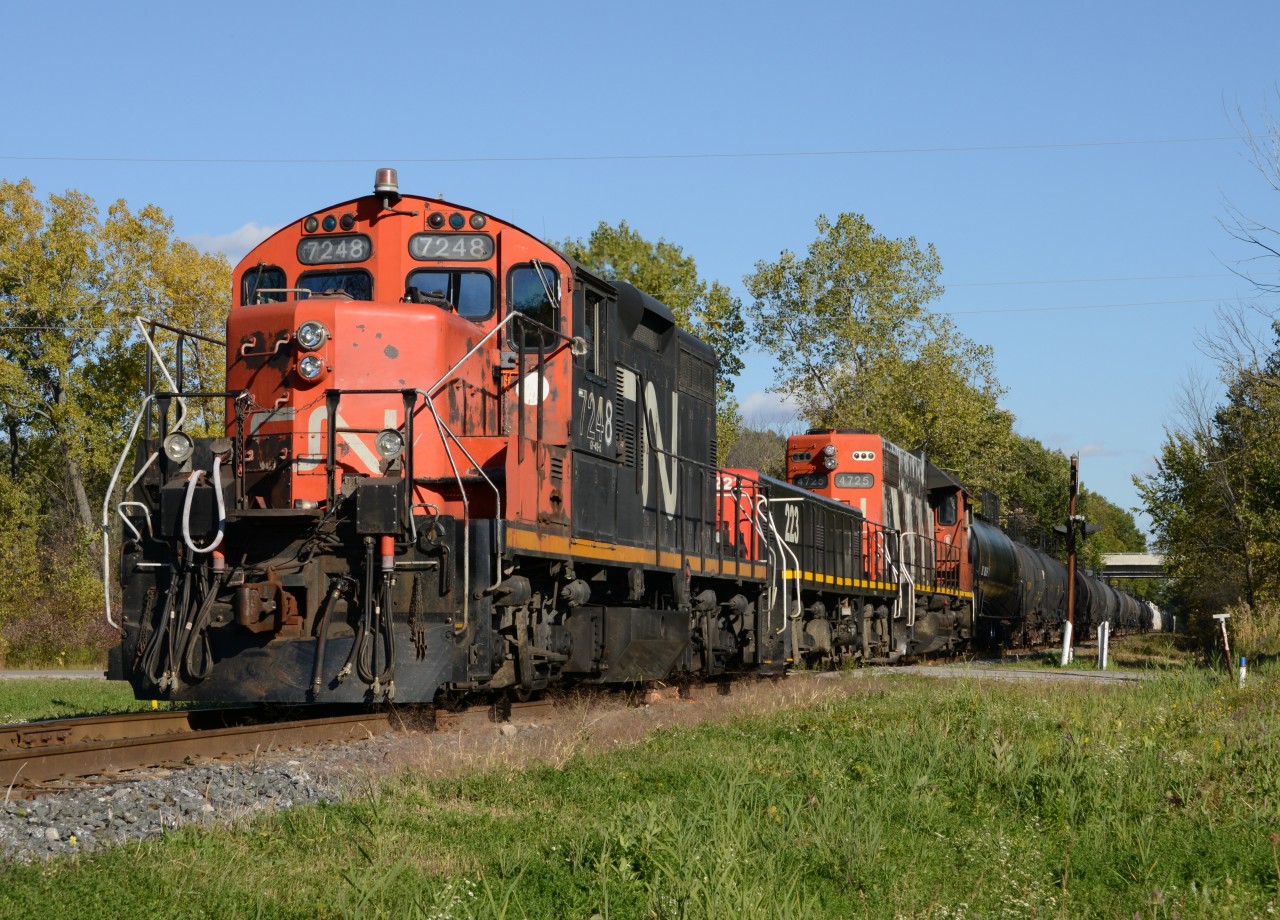 CN7248 with slug223 and CN4725 cross Tashmoo Avenue with a mix of tanker and hopper cars.