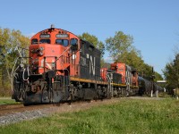 CN7248 with slug223 and CN4725 cross Tashmoo Avenue with a mix of tanker and hopper cars.
