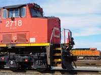 CN GE C44-9W 2718 resting at Roberts Bank, and BNSF ES44AC 6299 waiting for an inbound CP Coal train to pass by before heading out.