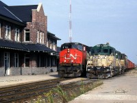 CN train 411 (MacMillan Yard to Sarnia via the Guelph Sub) passes by the station at Stratford with Bombardier HR616 2111 in the lead. On the track next to it sits a train of ballast cars with two Goderich-Exeter GP9's, 180 "Falstaff" and a 17x sister, which came from another operation of owner RailTex (they were originally built for the Quebec Cartier Mining railway). <br><br> The Goderich Exeter Railway, or GEXR, was created a year earlier in 1992 to operate CN's Goderich Sub (Stratford to Goderich line). In 1998, the GEXR would take over the Guelph Sub from CN (who leased the line to them) and handle its daily operations, as well as those on associated spurs and branches. In September 2014, it was announced CN would sell part of the Guelph Sub to GO Transit parent Metrolinx, with CN (at this point, actually GEXR) retaining rights for freight operation on the line. But there are rumours CN might be taking back operations when the lease comes up for renewal in the near future.