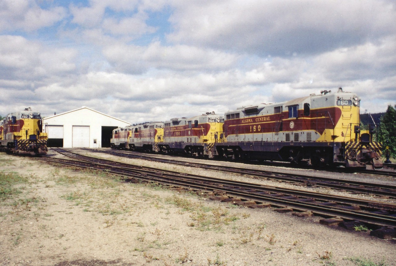 Hard to believe it was once like this. Sleepy ol' Hawk Jct. once had some life to it. In this image of the now gone diesel facility, we see from left: AC 150, 152 and hidden 166 and 159. On the right are AC 160, 164, 158 and 151. Out of sight behind that column are 184, 185 and 187; for a total of 11 units where now we are lucky to see any power, and if we do.......it is just CN. Shop building looks new, but it wasn't there long. So much has changed since the once distinctive Algoma Central Railroad was taken over by the Wisconsin Central in 1995; and in turn shortly after by the CN.