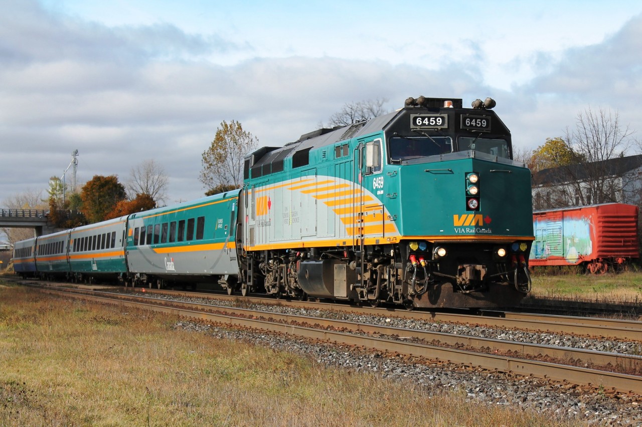 The eastbound lunchtime Via sets off from Woodstock on it's journey to Toronto. In the background the distinctive decorated boxcars.