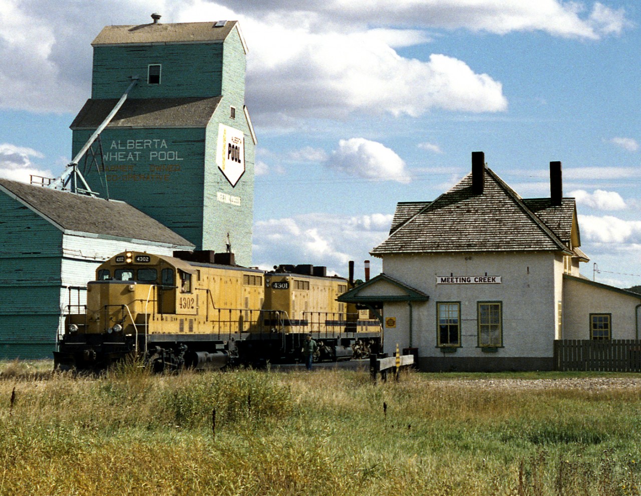 Northbound CWR wayfreight bound from Stettler to the CN interchange south of Camrose pulls up the former Canadian Northern station at Meeting Creek prior to lifting grain at the elevators