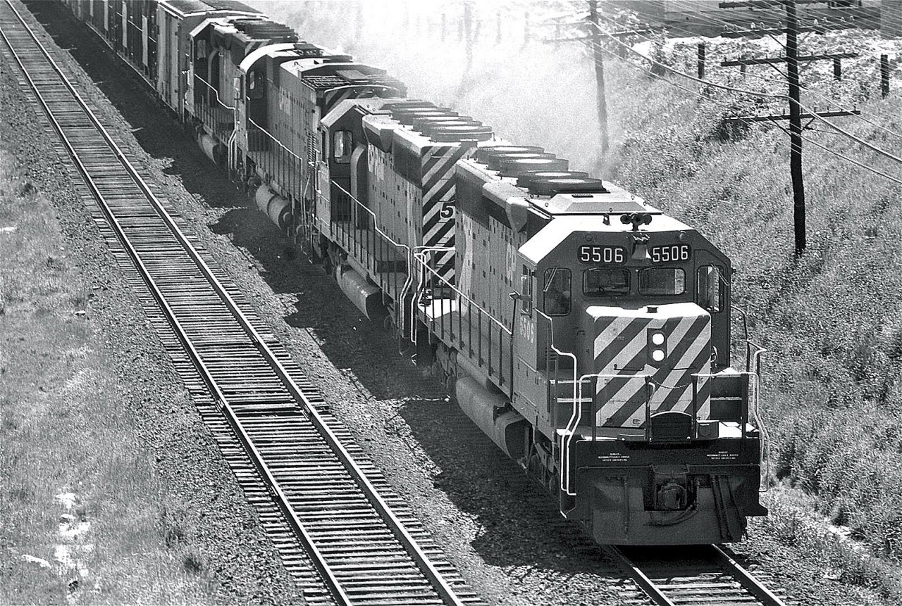 With a friendly wave from the crew, SD40 #5506 leads the pack from Toronto up the hill towards Agincourt.  This picture was taken from the Victoria Park bridge.  This teenage photographer never kept any notes, but circa 1975.  I'm pretty sure this is one of my earlier shots - I was probably about 14 when I snagged this image.  I was likely using my older brother's Pentax Spotmatic 1000... not sure if I had his permission that day or not.  Internet research shows this locomotive was built by GMD in 1966.  It was traded to East Coast Motive Power in 2000, and rebuilt by Alstom to become GCFX #3081.