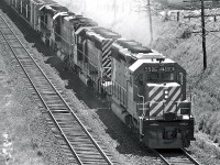 With a friendly wave from the crew, SD40 #5506 leads the pack from Toronto up the hill towards Agincourt.  This picture was taken from the Victoria Park bridge.  This teenage photographer never kept any notes, but circa 1975.  I'm pretty sure this is one of my earlier shots - I was probably about 14 when I snagged this image.  I was likely using my older brother's Pentax Spotmatic 1000... not sure if I had his permission that day or not.  Internet research shows this locomotive was built by GMD in 1966.  It was traded to East Coast Motive Power in 2000, and rebuilt by Alstom to become GCFX #3081.  
