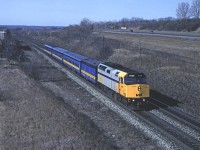 In the transition era between steam and electric heat on Via an F40PH leads some blue fleet cars  with a steam generator to keep everyone warm. The train is passing under Lemonville Road at the west end of Aldershot Yard. 