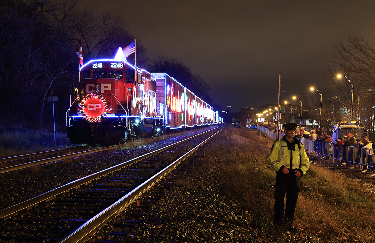 The CP cop keeps watch over to protect & control the crowd from fouling or getting close to the track. CP 01H-28 The Christmas spirt and cheer is in Hamilton, Ontario tonight as the crowd enjoys this year's Holiday train. As these train's brings lots of joy and christmas spirit to each city they stops in. Merry Christmas and Happy Holidays!!