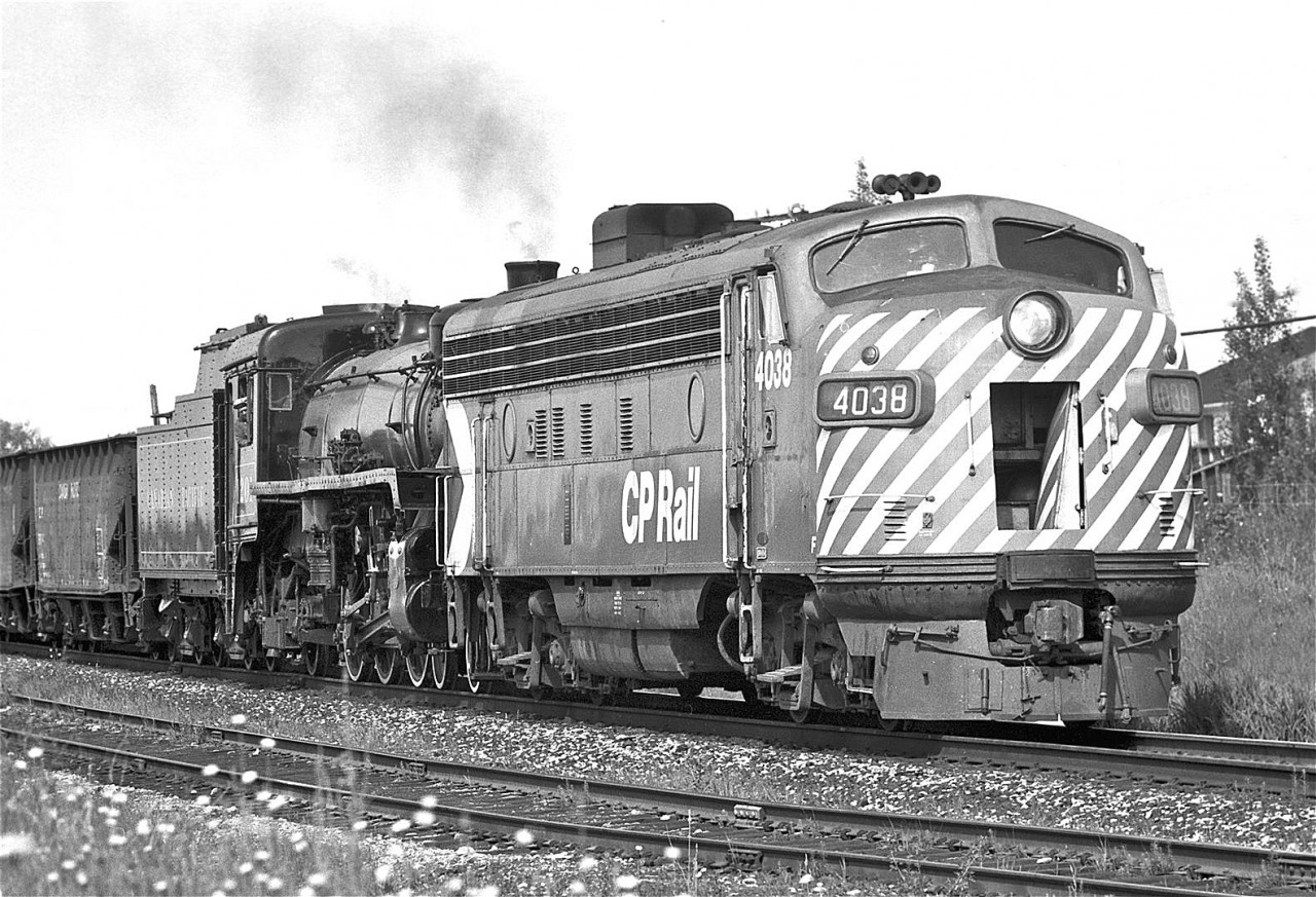 Have you read the children’s book “Alexander and the Terrible, Horrible, No Good, Very Bad Day”?  It is the humorous story of a young fellow who climbs out of bed only to have everything go wrong.  That pretty much describes my day on June 6th, 1976.
 
I was 15 at the time, and had recently joined the Ontario Rail Association.  This was during the final restoration phase of CPR #1201.  I had quickly become quite fascinated and attached to this locomotive.  The guys at John Street were kind enough to invite me to join them for the last upcoming turntable picture before it departed for Ottawa.  I was so excited that I had trouble sleeping the night before.  I overslept and arrived five minutes late for the photograph.  My new friends then invited me to spend the day chasing the locomotive.  At our first stop, this consist stormed by at an extremely high rate of knots.  We were shocked to see a diesel protecting the front end.  Further ruining the shot, the snout door of FP7-A, #4038, was wide open.  The idea of further pursuit was quickly abandoned

I’m sure I went home in a funk, climbed back into bed and pulled the covers over my head.  Fast forward 38 years and I’m looking at this image - and thinking it is kind of interesting.  Maybe it wasn’t such a bad day after all!

Internet research shows #4038 was built by GMD in London, Ontario, in 1951.  It was retired in 12/82.  It is on static display in Minnedosa, Manitoba.

I’ve tagged the GPS co-ordinates at John Street.  This is obviously incorrect – I have no idea where I snagged this photograph – but it was somewhere outside of downtown Toronto.