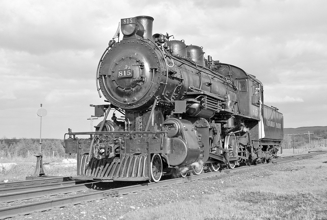 815 sits by herself near the shop. This was my favourite engine. I chose it because of its older appearance compared to 1057. The high mounted old-style headlight adds to its good looks. There was another D-10 1087 similar in appearance to 1057 that could have been used. The cut-down tender provided better backup view for the enginemen. It was supposed to be the last engine for that reason.  The three engines had to run backing up for 5 miles from Lambton Yard to Union Station. However, by the time I arrived at Lambton roundhouse the power was already together on the outbound shop track and I did not want to disturb things even though I had provided instructions in writing to marshal them 136, 815, 1057. 
  815 had been the shop boiler at Trenton for the winter and prior to that the yard engine at Peterboro. I wanted to give her one last fling on the mainline. Alas, it was too much for the old girl. At Streetsville she needed water as the tank was down more than half while the smaller (4,000 Gallon) 136 was less than half used. Water was again taken at Inglewood and Cataract. Upon her return to Lambton the boilermakers condemned her boiler as having been badly burned. She was scrapped.