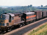 More 60's leased foreign power: CP RS18 8798 leads a 700-series Bessemer and Lake Erie F7A unit westbound through the curves of the Galt Sub at Mile 35, climbing up the Niagara Escarpment in Milton Heights near the present-day Kelso Conservation Area. Ballast or triple hoppers make up the majority of the train, behind a classic 40' stacked lettering boxcar, a pair of "slab side" covered hoppers, a gondola and two piggyback flats on the head end.
<br><br>
Along with the <a href=http://www.railpictures.ca/?attachment_id=16939><b>Union Pacific FA/FB's</b></a>, the B&LE F7A's and F7B's were another group of power leased by power-short CP in the 60's.