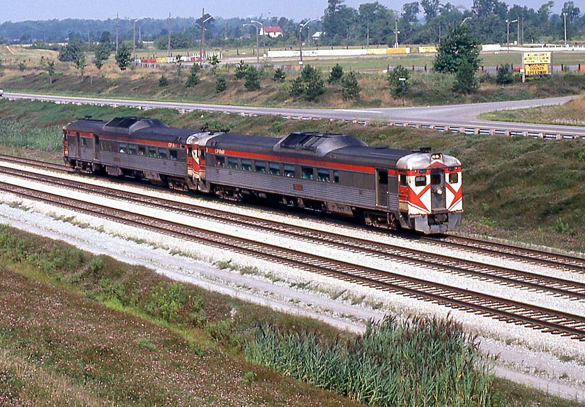 VIA train 181, running from Toronto ON to Buffalo NY, has just passed under the Welland Canal (just out of Welland). Power today is the usual Budd RDC cars, a former CP Rail RDC-2 and RDC-3 still in action red colours (possibly 9115 and 9021), both maintained by CP out of CP's John Street Roundhouse for VIA (as opposed to the dozens of VIA RDC's maintained out of CN's Spadina Roundhouse).

This train, formerly a TH&B train run with CP equipment, continued to run into the VIA era until April of 1981, via the CN Oakville Sub (CP running rights) from Toronto to Hamilton, TH&B Welland Sub from Hamilton to Welland, and Conrail CASO Sub from Welland to Buffalo.