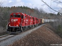 Ambling their way west across the top of the Oak Ridges moraine, CP 2282, 3027, and 2259 lead T07's train, including a 400,000lb wind turbine generator load, through a spot I find most appealing near Raglan, Ontario. It's hard to tell from the photo, but the power is atop a tall, albeit short, fill across a small dell which opens on the north (left) into a bucolic farm field. I imagine this would have been the location of a temporary trestle during the Ontario & Quebec Railway's construction... the deep cut the train is emerging from would have supplied the material to make it's existence short indeed. 1118hrs.