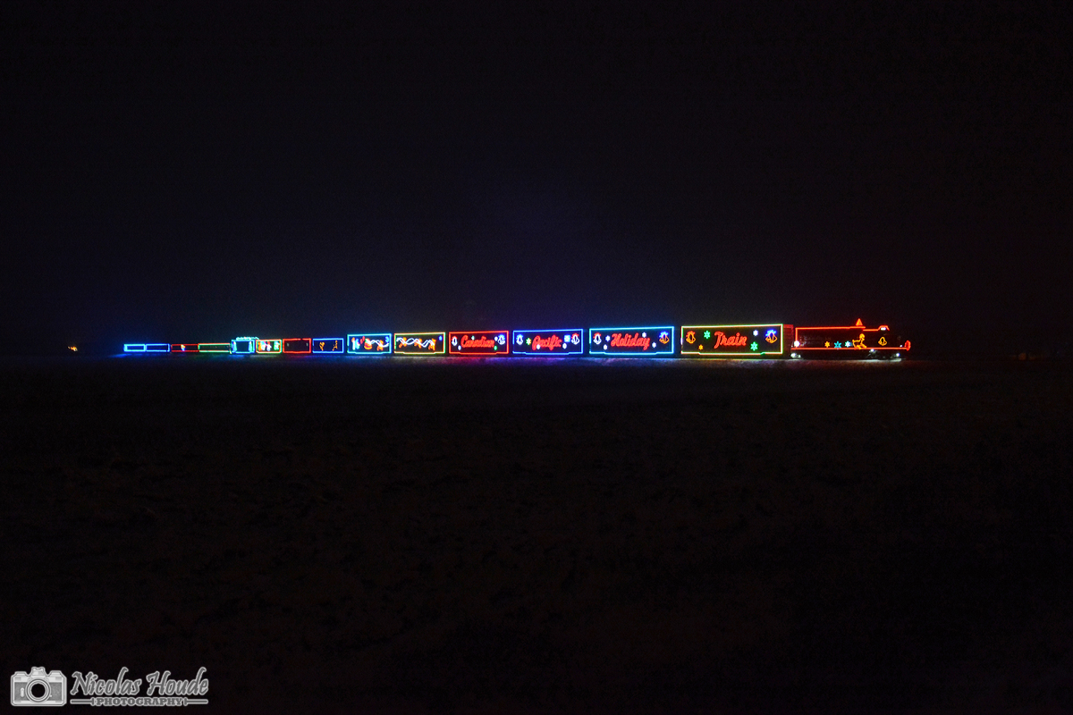 In the middle of the fields, and the night, the illuminated Canadian Pacific Holiday Train U.S. version is about to cross the border Canada/USA.