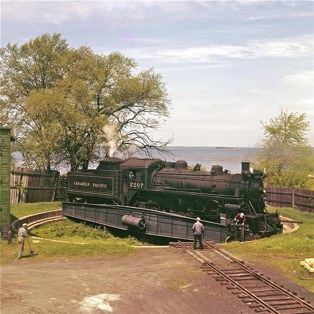 The turntable beside the three-stall engine house looks barely large enough to cater Pacific type #2207. The late Del Rosamond likely climbed on top of a boxcar to capture this image.  I've been told that one of Del's signature trademarks is that his photos were often taken from elevated positions.  Del served 30 years on the Pembroke Fire Department.  His family tells me that he had no fear of heights.