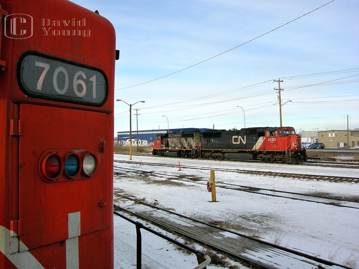 "Take advantage of the opportunities afforded to you." A field trip to Sarcee yard in Calgary to experience what railroading was about, a walk about the property and through a couple yard units including the CN 7061. While doing our walkabout Edmonton to Calgary manifest A442 arrived. Normally a nocturnal arrival into Sarcee, I recall the crew was a recrew and had been on duty close to 10 hours by the time they arrived. Here CN SD70i 5608 and CN GP40-2W 9555 run by after setting their train off into the yard. Within a few minutes the crew will park on the shop track closest to CN 7061 and the crew will end their all night long excursion over the Three Hills Sub and report off duty.