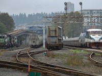 The morning Amtrak "Cascades" is passing through New Westminster and headed for Vancouver behind AMTK nos.465 & 48. On the left can be seen Sapperton Sky Train station and a line of BNSF power units.