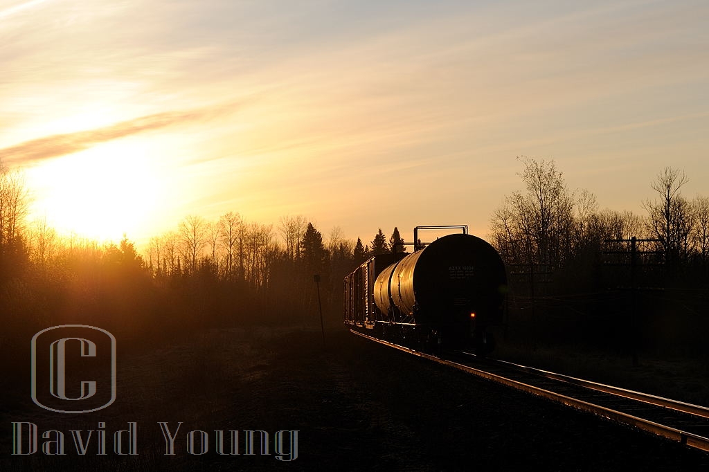 Spring Sunrise. As the days get longer the better your chances were of catching the daily freight ex Fort Frances to Thunder Bay arrive into the Lakehead. We are about 40 minutes into the daylight hours as CN A436's tailend passes by me at mileage 15, approaching B/E OCS limits at Evans as the sun peaks above the still stark trees. Another month will pass before any leaves are seen on the trees the Thunder Bay region.