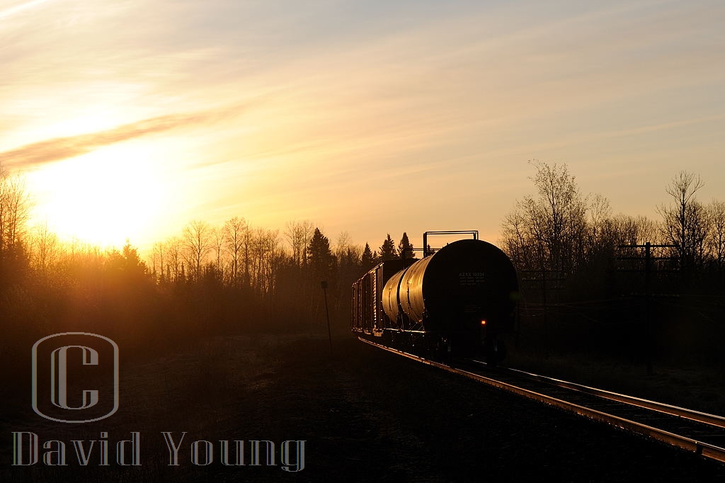 Spring Sunrise. As the days get longer the better your chances were of catching the daily freight ex Fort Frances to Thunder Bay arrive into the Lakehead. We are about 40 minutes into the daylight hours as CN A436's tailend passes by me at mileage 15, approaching B/E OCS limits at Evans as the sun peaks above the still stark trees. Another month will pass before any leaves are seen on the trees the Thunder Bay region.