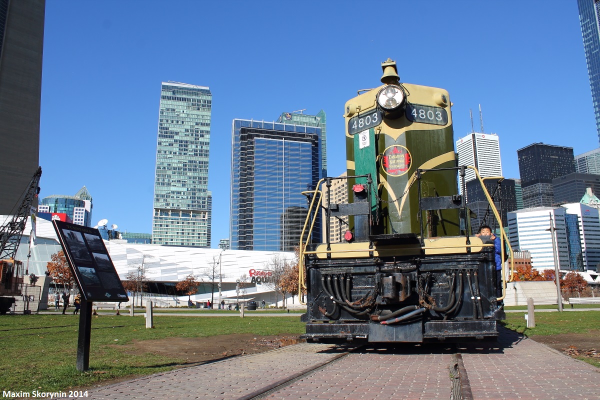 On a peaceful Sunday afternoon in downtown Toronto, CN 4803 sits retired at Roundhouse Park on display, something it has been doing for many years. In the background is the Toronto skyline, to the left a portion of the CN Tower can be seen, standing 457M in the air, and a display sign noting several things about #4803.