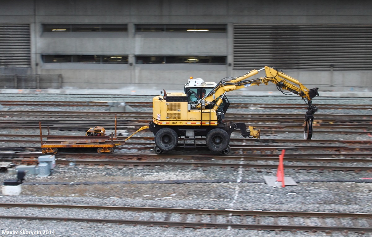 Today, I decided the visit a famous attraction in Toronto, the Ripley's Aquarium. While crossing the SkyWalk on the way there, I saw that down the tracks this particular machine was working on the tracks in the distance. After visiting the aquarium, I stopped at this spot right behind it for a while and heard a few blasts of a odd sounding air horn. Minutes later, I see this thing speeding down the tracks and I decided to try a pan shot as this machine will just fit in the camera frame, and it was going fast enough for a good one. Thankfully I didn't screw up, and I think it turned out fine. The machine likely belongs to the Toronto Terminals Railway which owns the tracks around Toronto's Union Station which is just to the right of where this image was taken. I believe it used for replacing ties. I've seen one of these before also being transported on the Canadian National Newmarket Subdivision in Huntsville, ON.